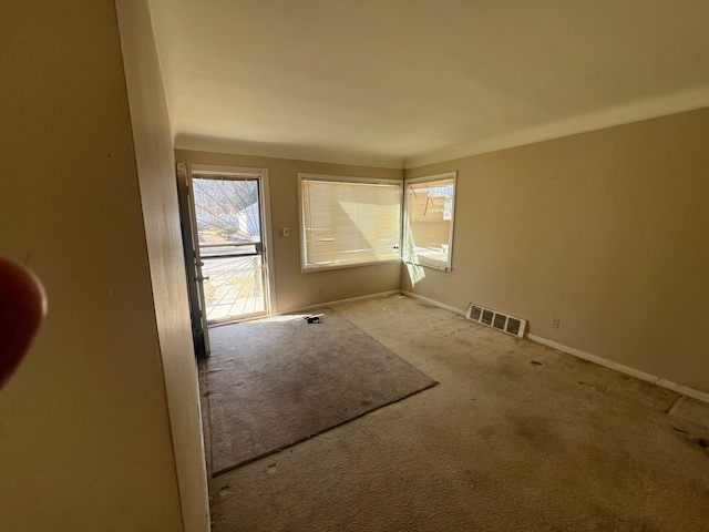 carpeted empty room featuring visible vents and baseboards