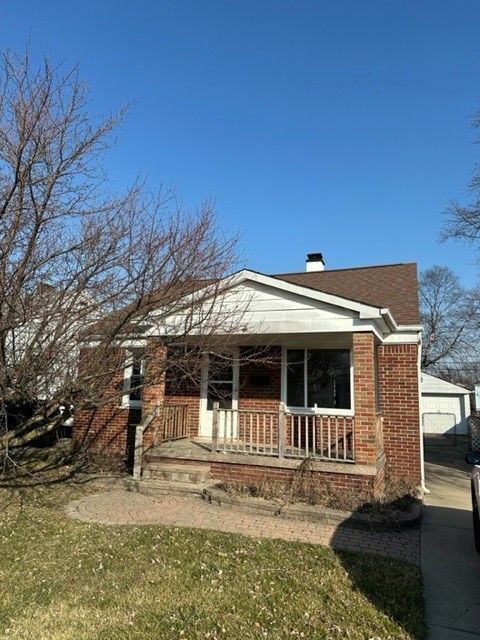 bungalow-style home featuring brick siding, a porch, and a chimney