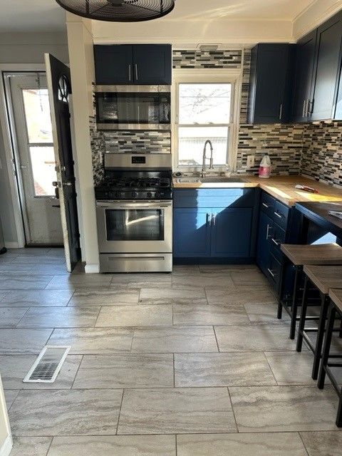 kitchen with a wealth of natural light, stainless steel appliances, tasteful backsplash, and visible vents