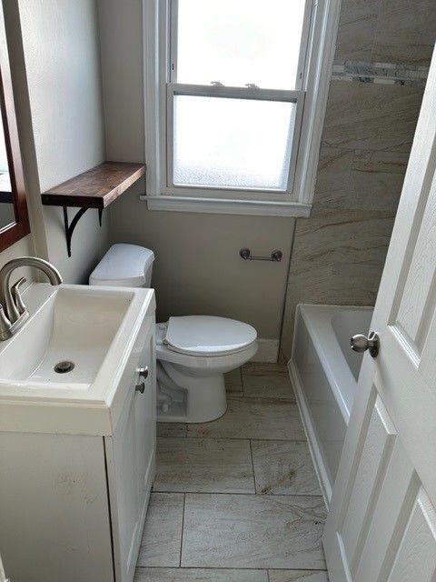 full bathroom featuring a bathtub, toilet, and vanity