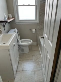 24640 Wilmot Ave, Eastpointe, MI 48021 - bathroom with toilet, vanity, a tub, tile patterned flooring, and baseboards