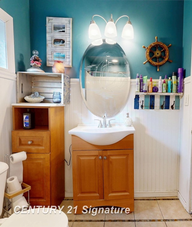 bathroom featuring toilet, wainscoting, vanity, and tile patterned flooring