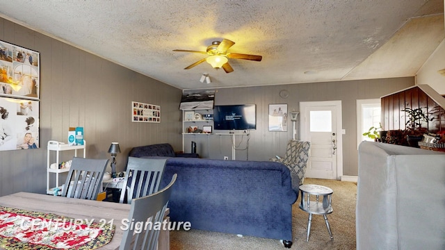 living room with carpet flooring, a textured ceiling, and ceiling fan