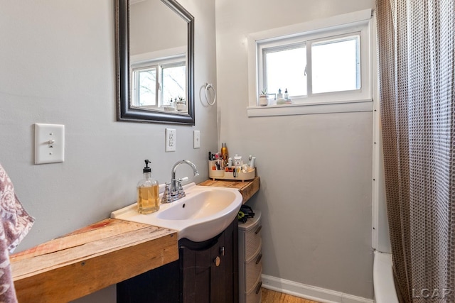 bathroom featuring vanity, a shower with shower curtain, toilet, and baseboards