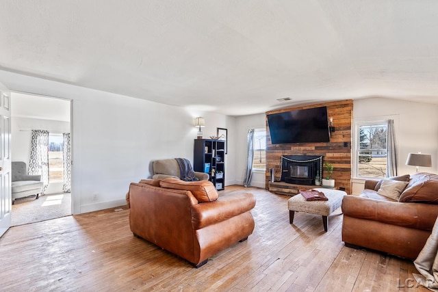 living room with lofted ceiling, plenty of natural light, and light wood-type flooring