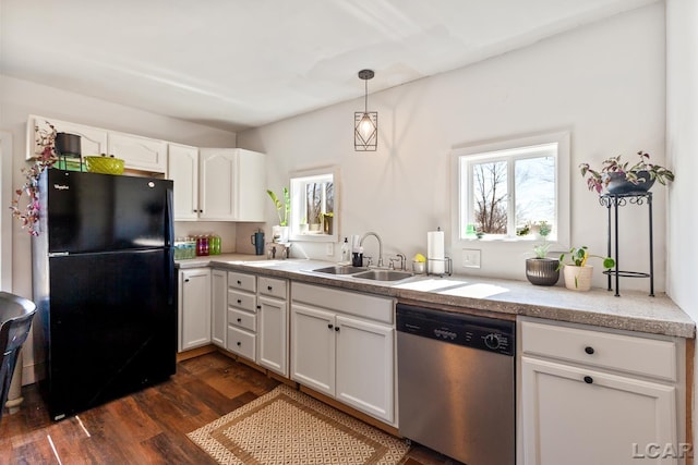 kitchen with white cabinetry, dark wood finished floors, freestanding refrigerator, a sink, and stainless steel dishwasher