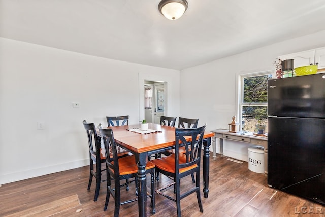 dining room featuring wood finished floors and baseboards