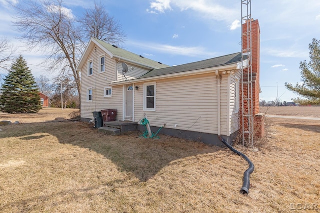 rear view of house with a lawn and a chimney