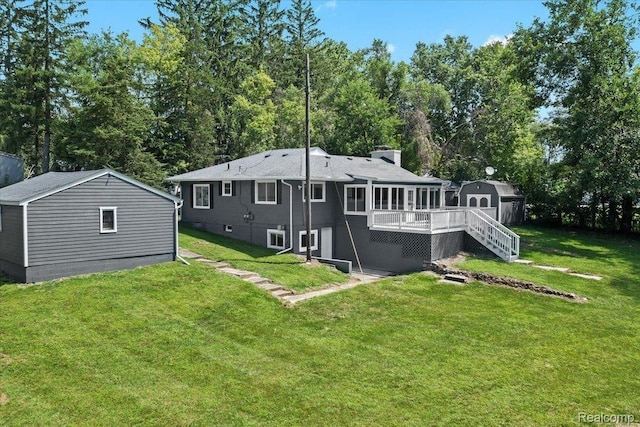 back of property featuring a shed, stairs, an outdoor structure, a deck, and a lawn