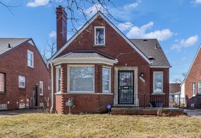 bungalow featuring a front lawn, brick siding, and a chimney