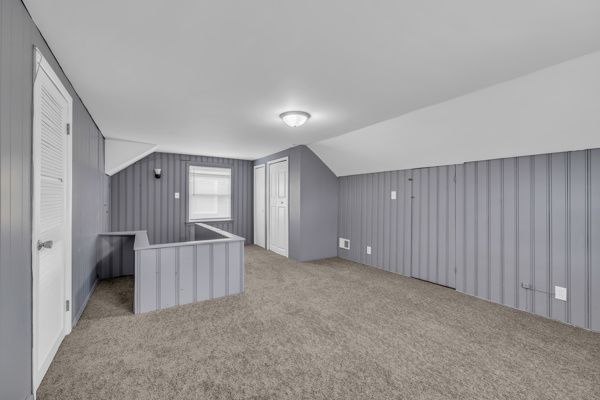 bonus room featuring lofted ceiling and carpet flooring