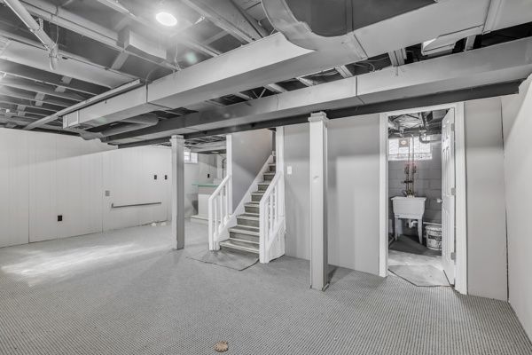 basement featuring stairs and a sink