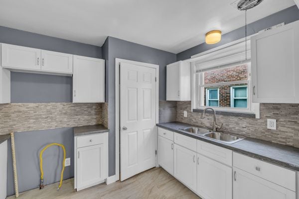 kitchen with white cabinetry, tasteful backsplash, and a sink