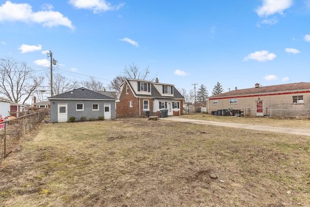 view of front of home featuring a front yard, fence, and brick siding