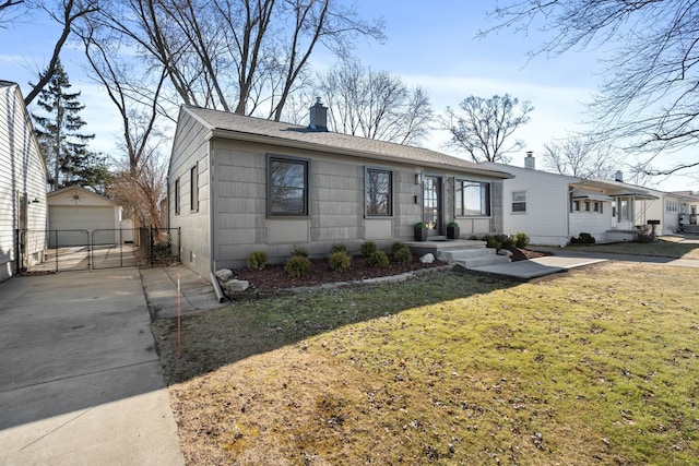 ranch-style home with a detached garage, a front yard, a chimney, an outdoor structure, and driveway