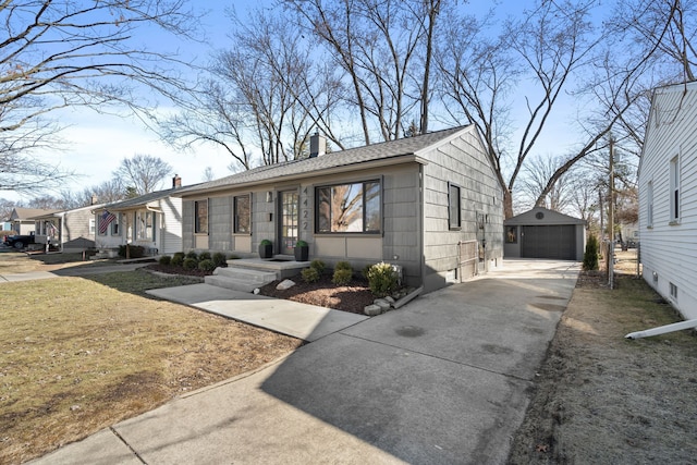 view of front of property with an outbuilding, concrete driveway, a chimney, and a garage