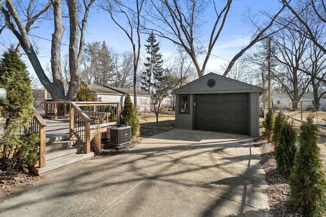 detached garage featuring central air condition unit and driveway