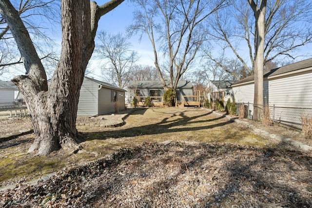 view of yard featuring a wooden deck and fence