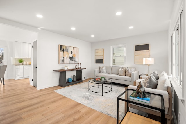 living area featuring light wood finished floors, plenty of natural light, recessed lighting, and baseboards