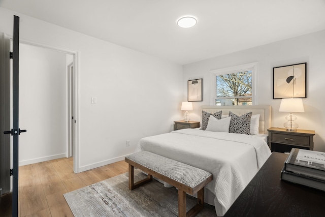 bedroom with light wood finished floors and baseboards