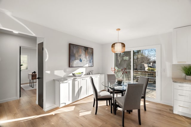 dining room with a healthy amount of sunlight, light wood-type flooring, and baseboards