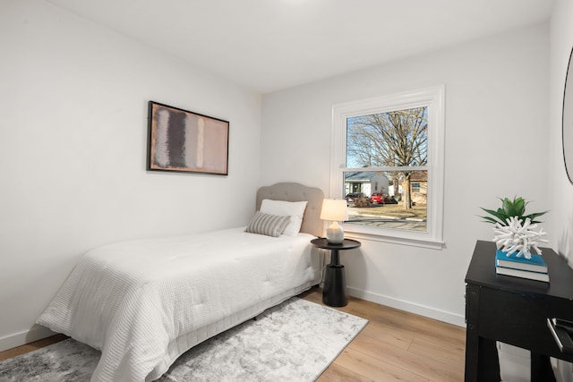 bedroom with baseboards and wood finished floors