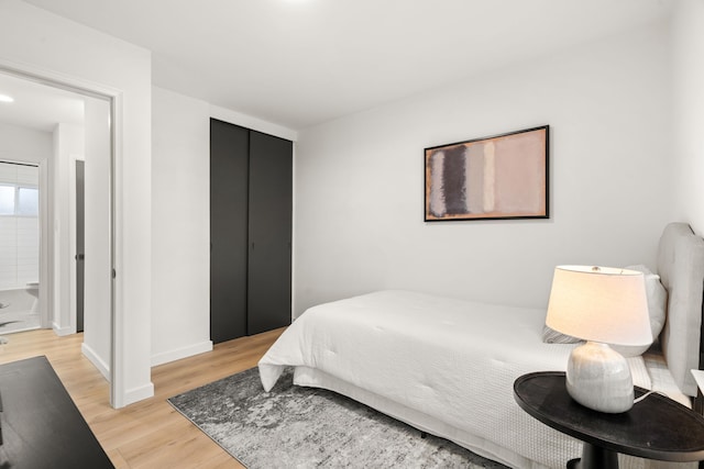 bedroom with light wood-style flooring and baseboards