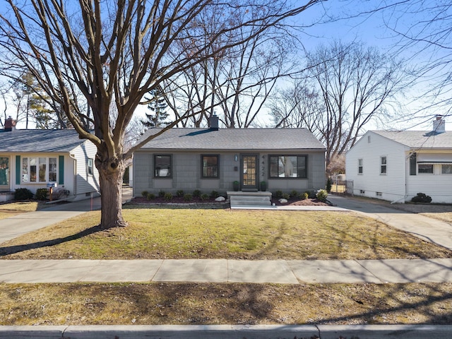 view of front of property featuring a shingled roof, a front yard, driveway, and a chimney