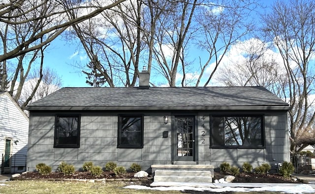 view of front of home featuring roof with shingles and a chimney