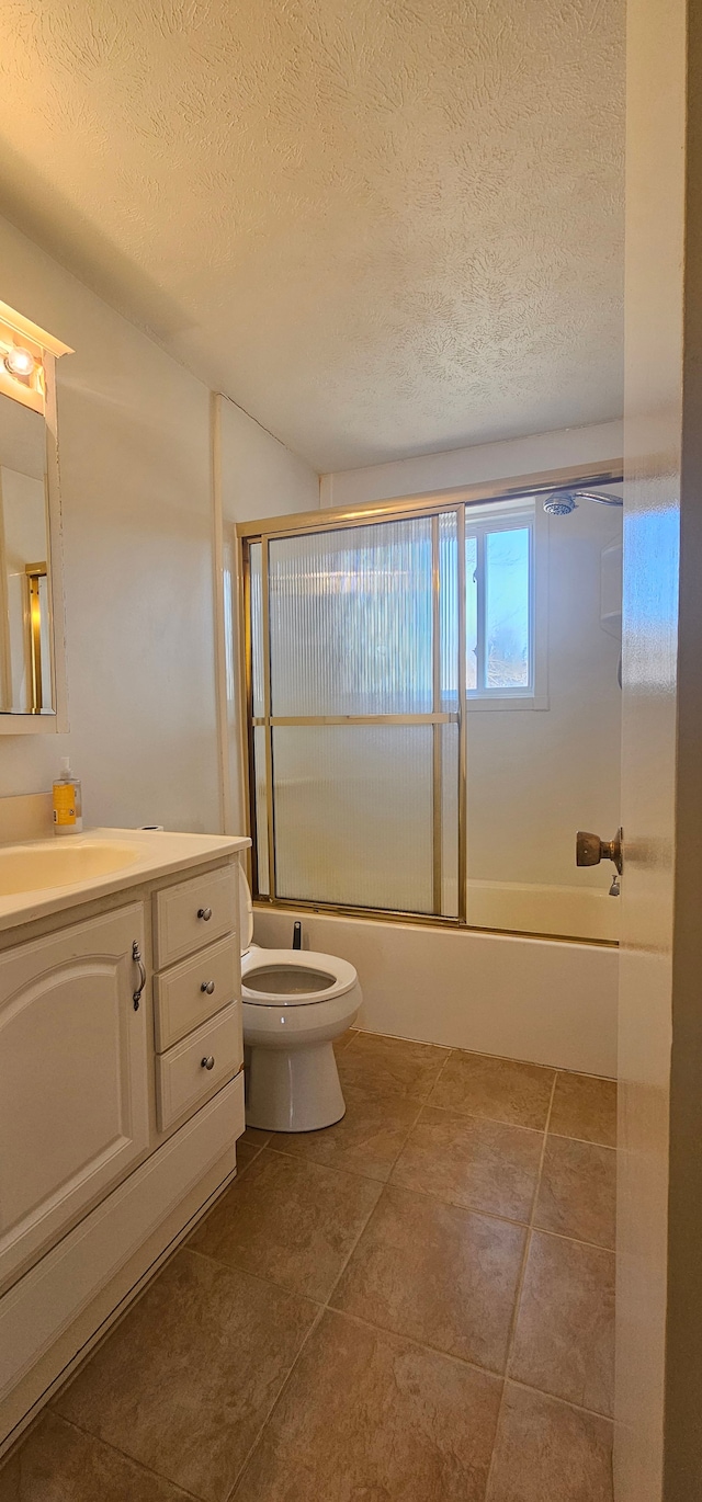 bathroom with vanity, toilet, shower / bath combination with glass door, and a textured ceiling