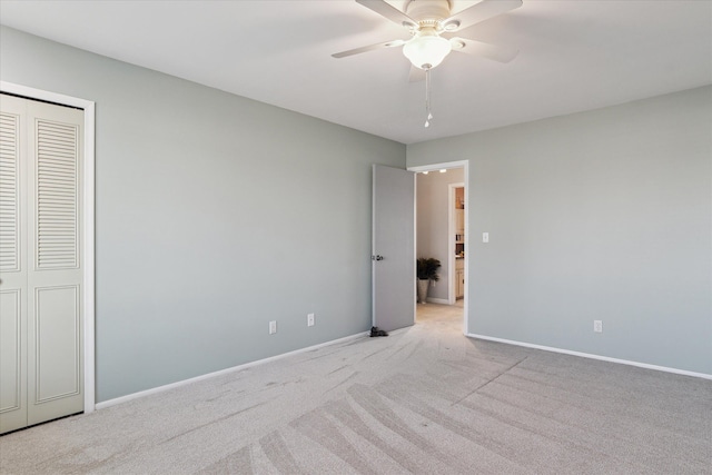 unfurnished bedroom with a closet, ceiling fan, baseboards, and carpet