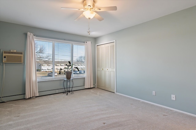 carpeted empty room featuring a ceiling fan, baseboards, and a wall mounted AC