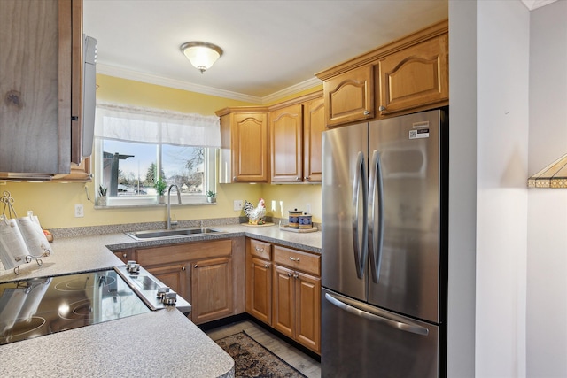 kitchen featuring crown molding, light countertops, range with electric stovetop, freestanding refrigerator, and a sink