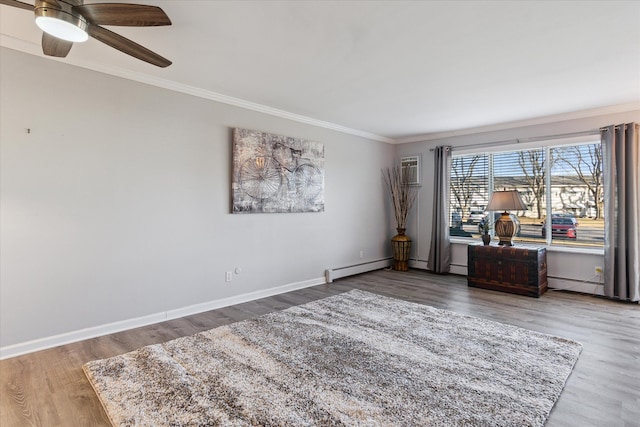 unfurnished room featuring a baseboard heating unit, ceiling fan, crown molding, baseboards, and wood finished floors