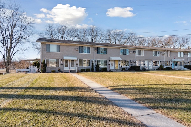 view of property with a front lawn and brick siding