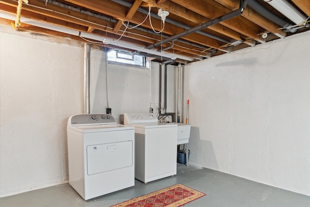 clothes washing area featuring laundry area, washing machine and dryer, and a sink