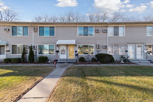 view of property featuring brick siding and a front lawn