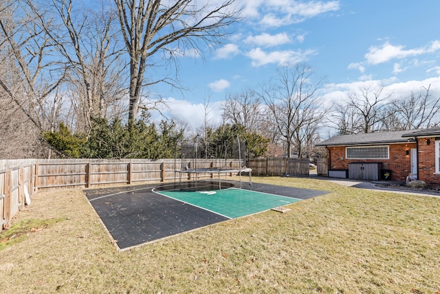 view of yard with a trampoline and a fenced backyard