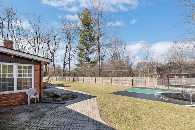 view of yard with a patio, a trampoline, and a fenced backyard