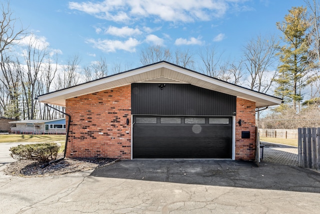 garage with fence and driveway