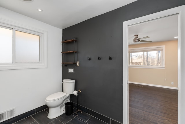 bathroom with visible vents, baseboards, toilet, and a ceiling fan