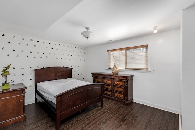 bedroom with visible vents, baseboards, and wood finished floors