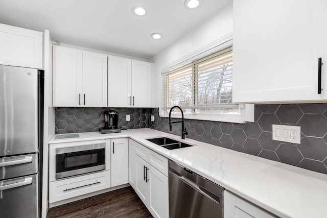 kitchen with white cabinetry, stainless steel appliances, and a sink