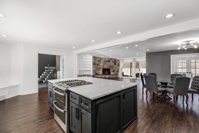 kitchen with range with two ovens, french doors, open floor plan, and dark wood-style flooring