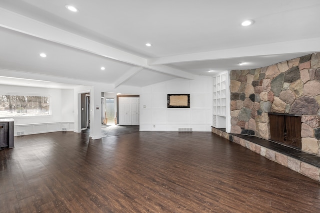 unfurnished living room featuring recessed lighting, a stone fireplace, wood finished floors, and vaulted ceiling with beams