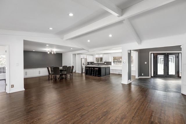 living room with baseboards, dark wood finished floors, vaulted ceiling with beams, recessed lighting, and french doors