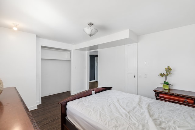 bedroom with a closet, baseboards, and wood finished floors