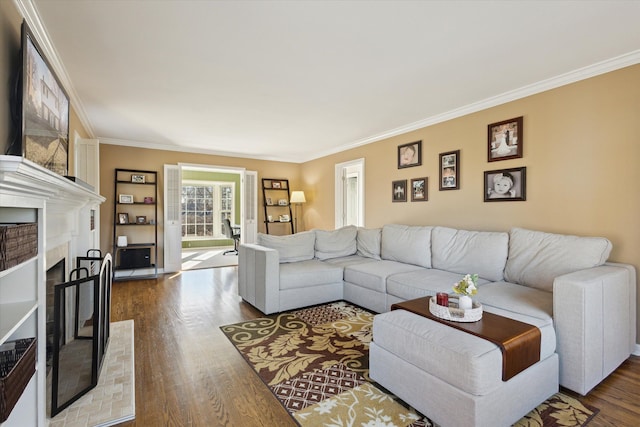 living area with dark wood-type flooring, a brick fireplace, and ornamental molding