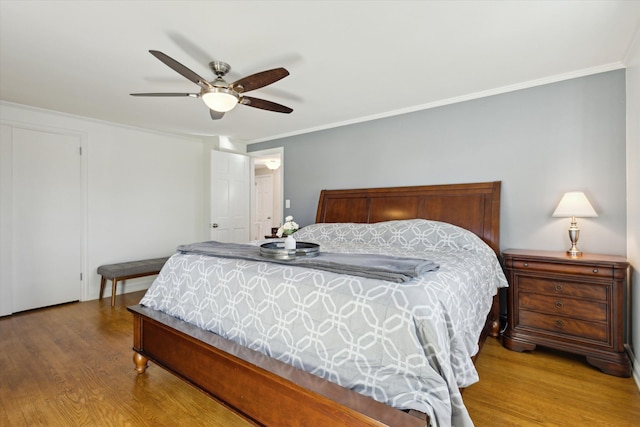 bedroom with crown molding, wood finished floors, and ceiling fan