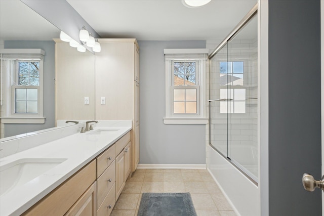 full bathroom featuring plenty of natural light, baseboards, and a sink